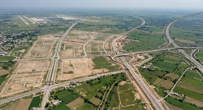 Aerial view of Faisal Town Phase 2 layout showing road network, motorway interchange, and nearby airport.