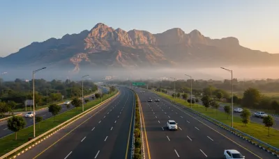 A wide-angle landscape photograph of the newly paved Margalla Avenue highway in Islamabad, leading towards the scenic Margalla Hills.