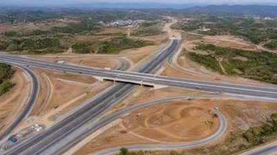 A high-resolution drone shot of the M-1 Motorway interchange under construction, showing yellow machinery and infrastructure progress near Sector D-12.