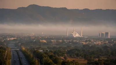 Cinematic aerial view of Islamabad skyline at dawn with Margalla Hills and Faisal Mosque shrouded in morning mist.