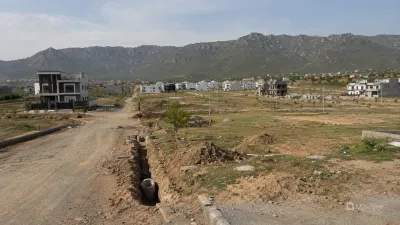 Delayed development work in Park Enclave Islamabad, showing unfinished roads, open utility trenches and partially developed residential plots.