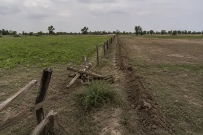 "Disputed rural land boundary with broken fence, representing a land ownership dispute"