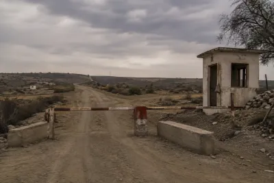 "Rural security checkpoint on a disputed housing society boundary road"