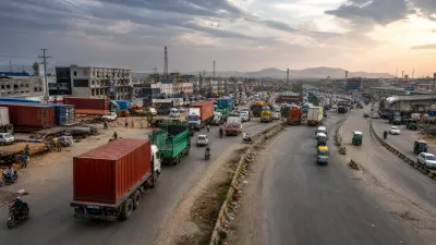 Busy Rawat T-intersection area with large cargo trucks and commercial activity.