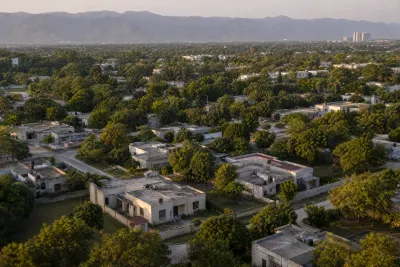 Aerial view of a grid of single-storey government housing plots with garden space between them in Islamabad.