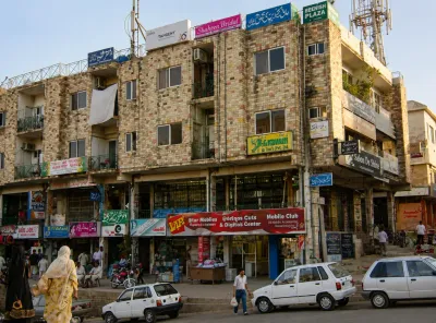 Aged but well maintained commercial shopfronts with lowered shutters in an established Islamabad Markaz.