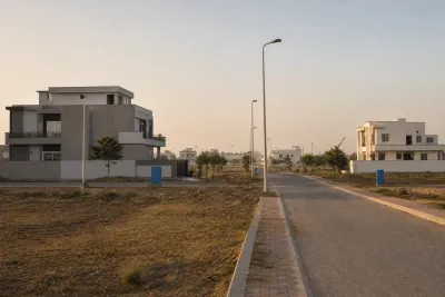 Formally laid-out residential street with evenly spaced plots and utility poles in an Islamabad housing sector.