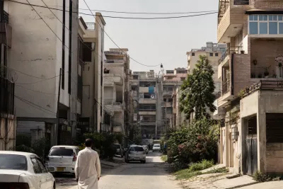 Densely built residential street with closely spaced small apartment buildings and narrow lanes.