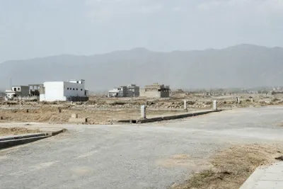Open land with basic road grading and boundary markers, showing an early stage of sector development.