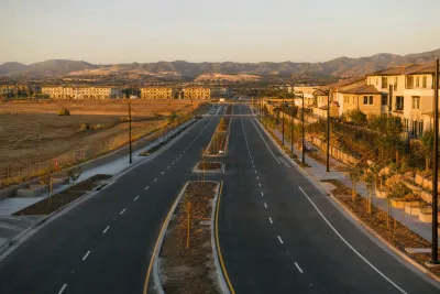 Modern boulevard under construction with partial landscaping inside a large planned housing scheme.