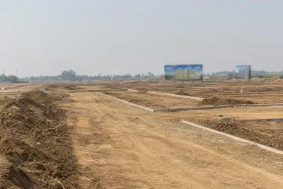 Early-stage development site with basic road grading and open land in the distance.