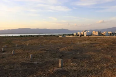 Open undeveloped land with scattered boundary markers and hills visible in the distance.