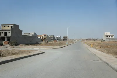 Large residential area with basic road infrastructure, a mix of completed houses and empty plots.