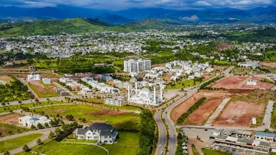 Aerial view of Park View City Islamabad showing residential development, roads, green spaces and surrounding Margalla Hills.