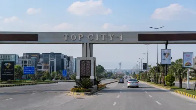 Commercial plazas and asphalt roads in Block A of Top City-1 near Islamabad Airport.