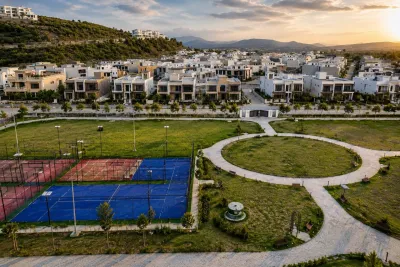 Aerial view of a gated housing society in Islamabad with modern villas, tennis courts and a landscaped community park