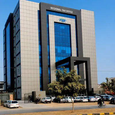 Exterior view of an FBR Regional Tax Office building with blue-glass windows, parked vehicles, and a modern government office façade.