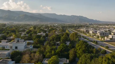 Aerial view of F-11 Islamabad showing tree-lined residential streets, modern homes, dense greenery, and the Margalla Hills in the background.