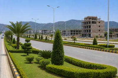 Completed landscaped boulevard with modern streetlights and surrounding development, set against green hills, illustrating infrastructure and visible progress in a growing property market.