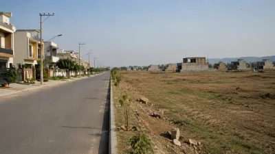 Partially developed housing scheme in Islamabad showing built-up street next to undeveloped plots