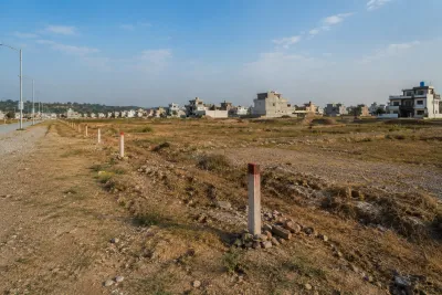 Undeveloped plot with boundary pegs on the outskirts of Islamabad awaiting infrastructure development
