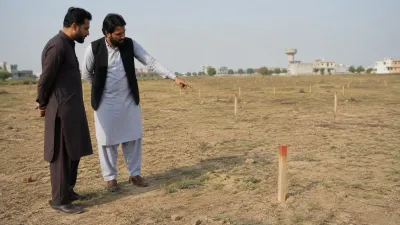 Buyer and site representative checking boundary markers to confirm physical possession of a plot